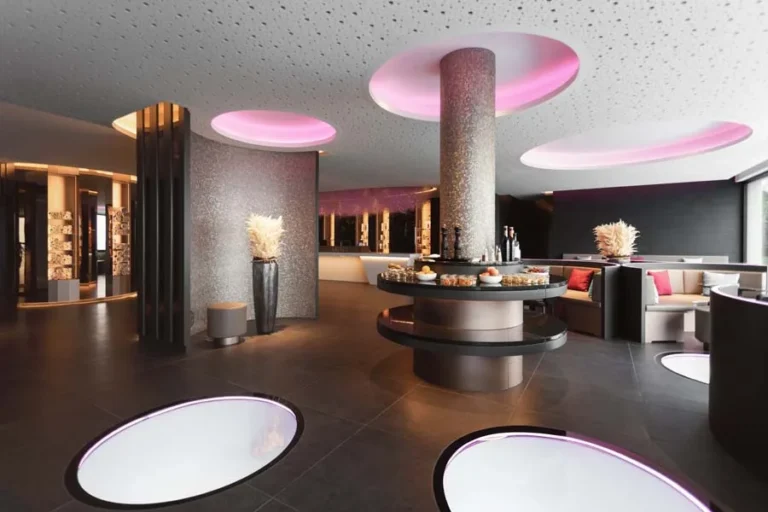 Akari Lounge mit schimmernder Mosaiksäule und pink beleuchteter Deckenkulisse