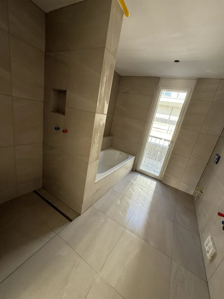 Rohbau-Bad mit eingefliesster Wanne, Nische und Steinoptik-Boden
