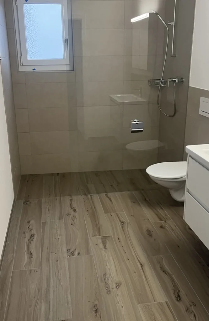 Bodengleiche Dusche mit Holzoptik-Boden und beiger Wandfliese