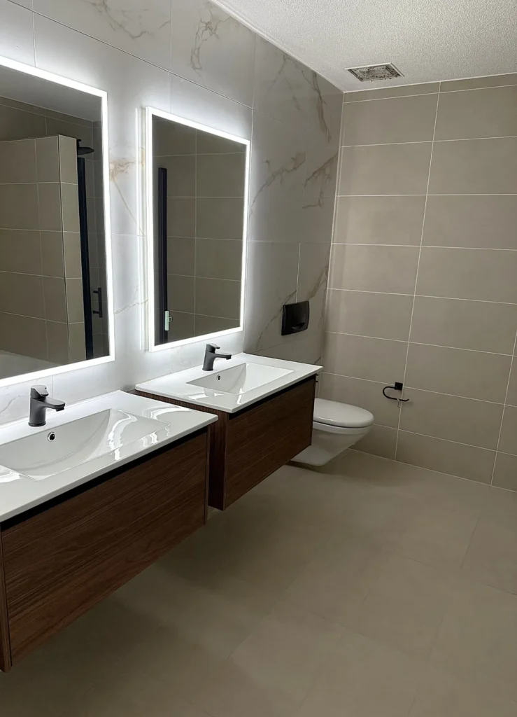 Elegantes Bad mit Doppelwaschtisch, LED-Spiegeln und Marmoroptik-Wand