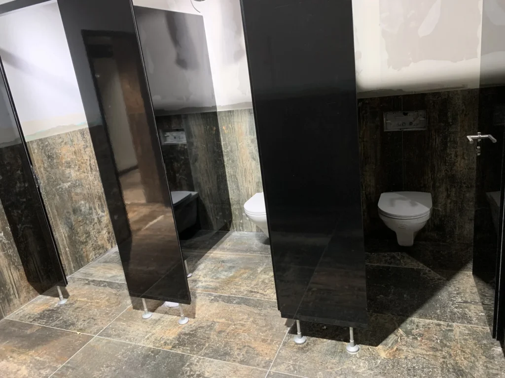 WC-Kabinen mit dunklem Grossformat-Feinsteinzeug in Metall-Rost-Optik