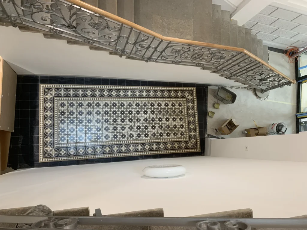 Historischer Mosaikboden im Treppenhaus mit schmiedeeisernem Jugendstil-Geländer