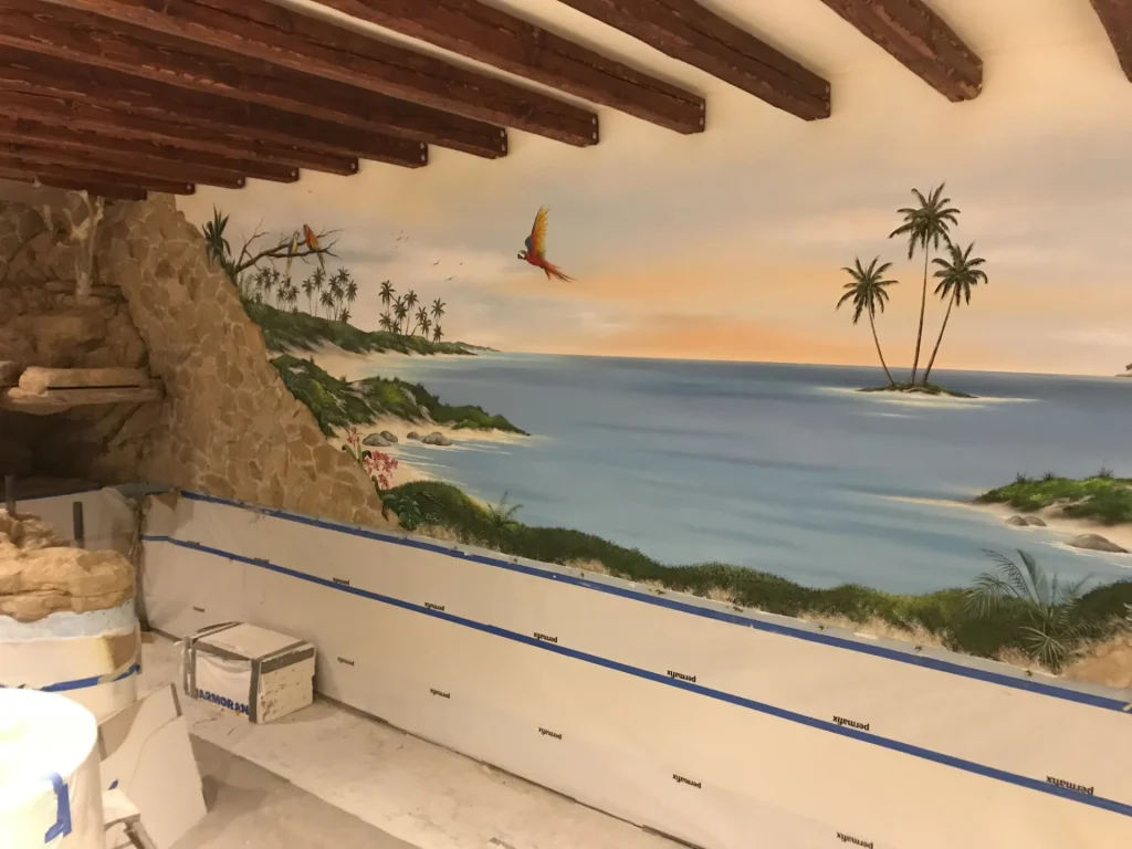 Wandmalerei mit Strandmotiv über Natursteinwand im Poolraum