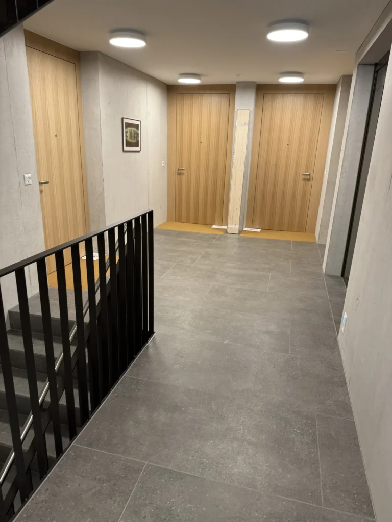 Grossformatiger Feinsteinzeugboden in Betonoptik im Treppenpodest