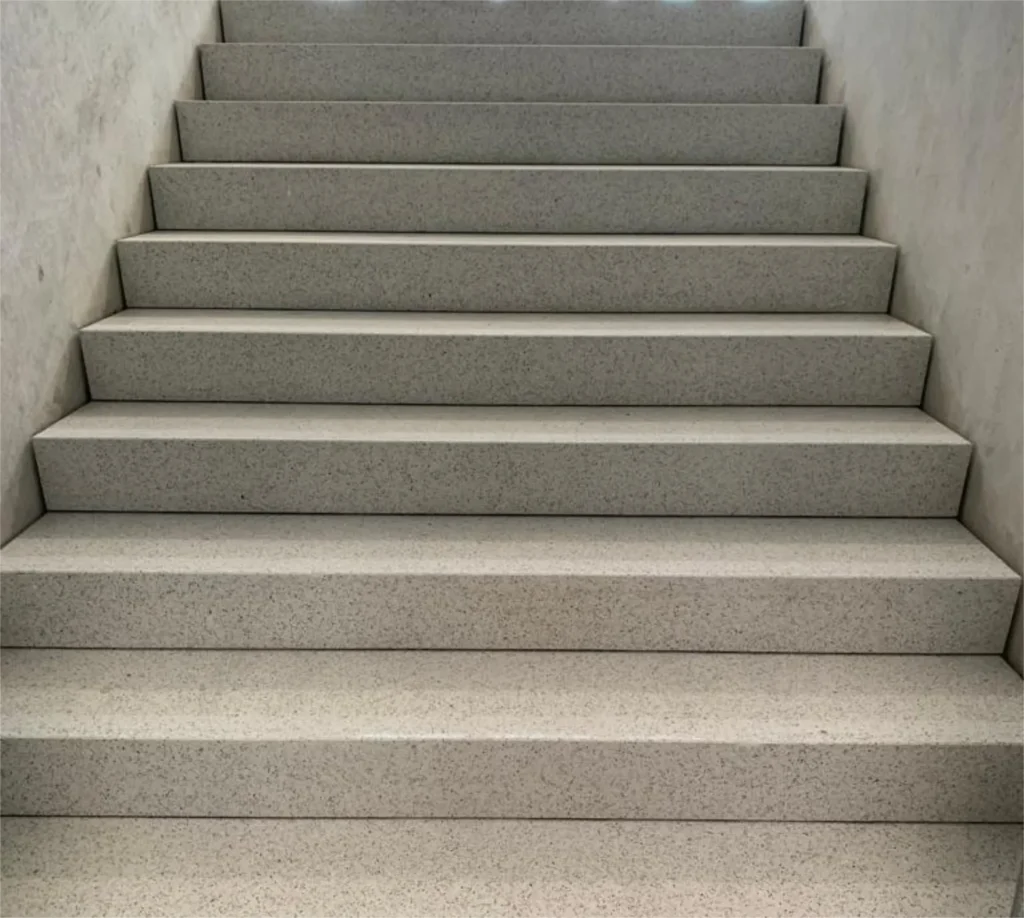 Terrazzo-Treppenhaus von oben mit Metallgeländer und Holzhandlauf