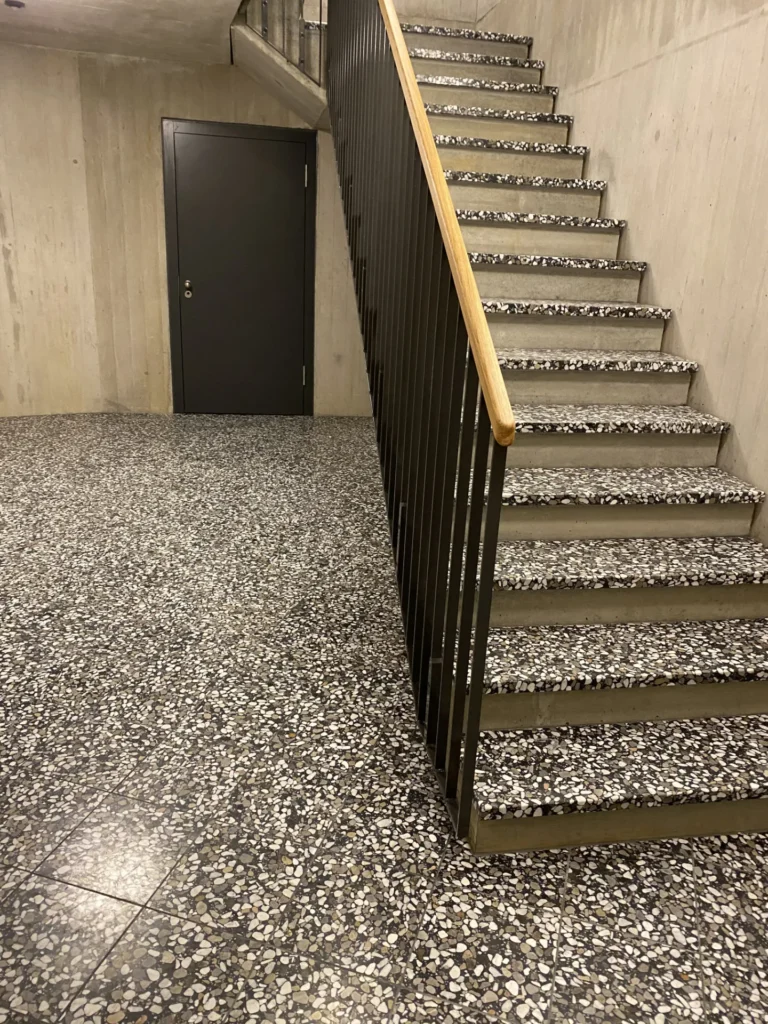 Schwarz-weisse Waschbeton-Terrazzo-Treppe im Betonkeller