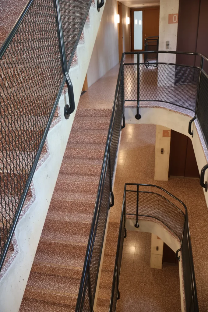 Ziegelroter Terrazzo mit Kalksteinkorn im mehrgeschossigen Treppenhaus
