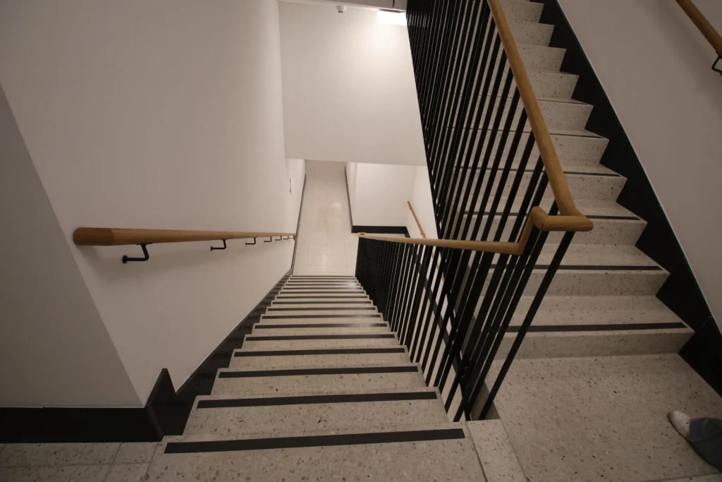 Schwarz-weisse Terrazzo-Treppe mit Antirutschstreifen im Treppenhaus